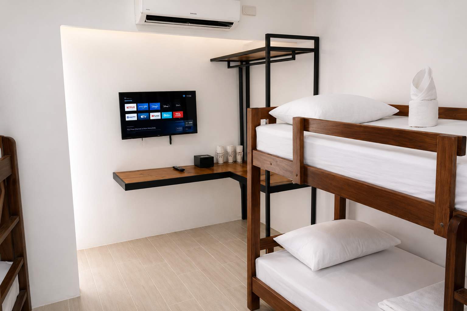 Studio unit at Mayumi Lodge with bunk beds, a wall-mounted smart television, split-system air conditioner and wooden desk shelf