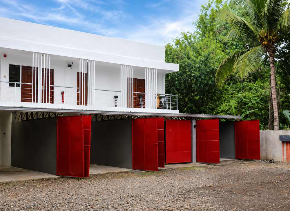 Free private on-site parking bays at Mayumi Lodge with red steel doors beneath the guest rooms